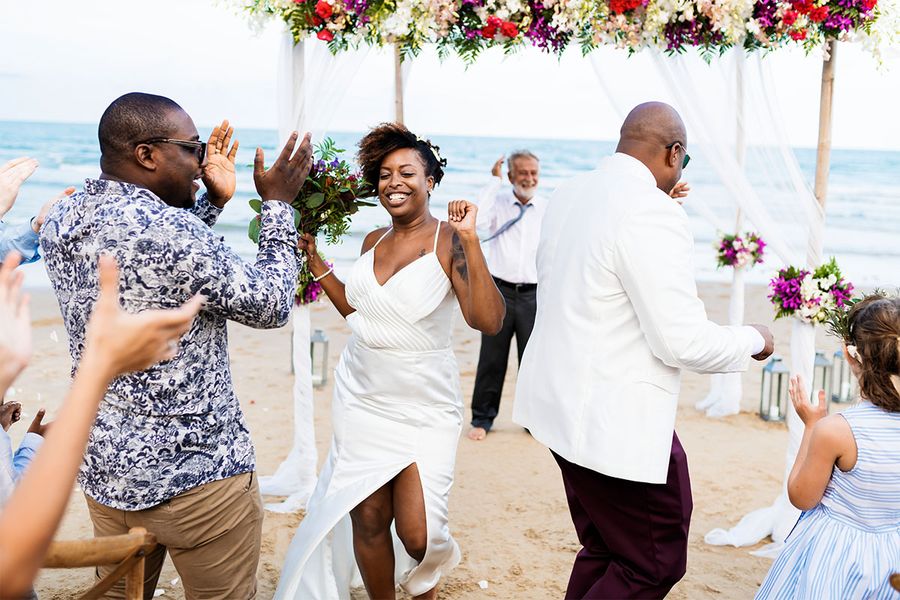 Un grupo de boda baila en la playa durante la recepción, capturando un momento alegre para la checklist de fotos de la recepción de boda.