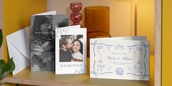 Tres invitaciones de boda personalizadas de Hofmann sobre una estantería, con distintos textos y mensajes para inspirarte sobre qué escribir en una invitación de boda.