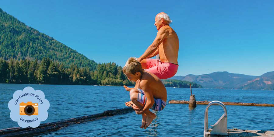 Un hombre mayor y un niño saltan al mar, capturando un alegre momento de verano para el concurso de fotos de verano de Hofmann.