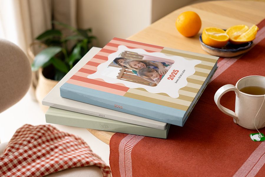 Una pila de coloridos álbumes del año Hofmann con diferentes diseños, apilados en una mesa de café.