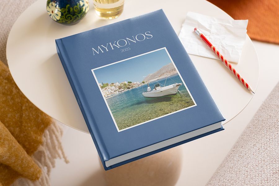 Ideas sobre qué escribir en un álbum de fotos de viajes Mykonos 2025, con un lápiz listo para anotar recuerdos junto a frases bonitas para álbumes de fotos.