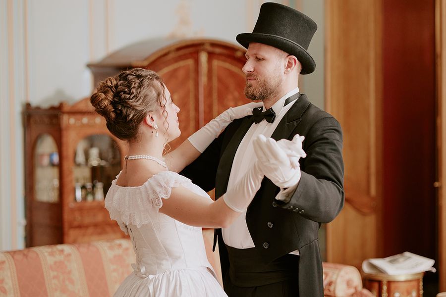 Una foto de boda kitsch y retro de una pareja con vestidos de estilo Bridgerton, mostrando las tendencias de bodas para 2026 y los últimos estilos de vestidos de novia con Hofmann.