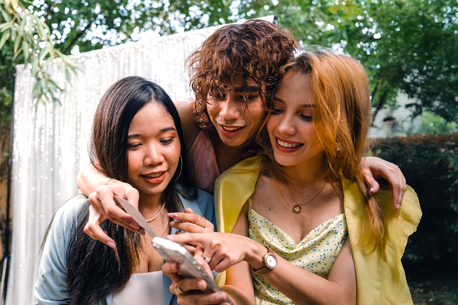 Tres amigos vestidos de gala en una boda participan en una búsqueda del tesoro fotográfica, como inspiración para Hofmann y para juegos de boda y actividades para invitados.
