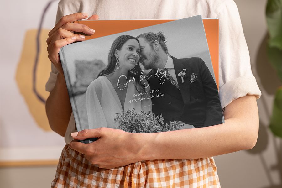 Una mujer sostiene en sus manos un coffee table book de boda personalizado de Hofmann, como inspiración para un álbum decorativo de boda y un coffee table book personalizado.