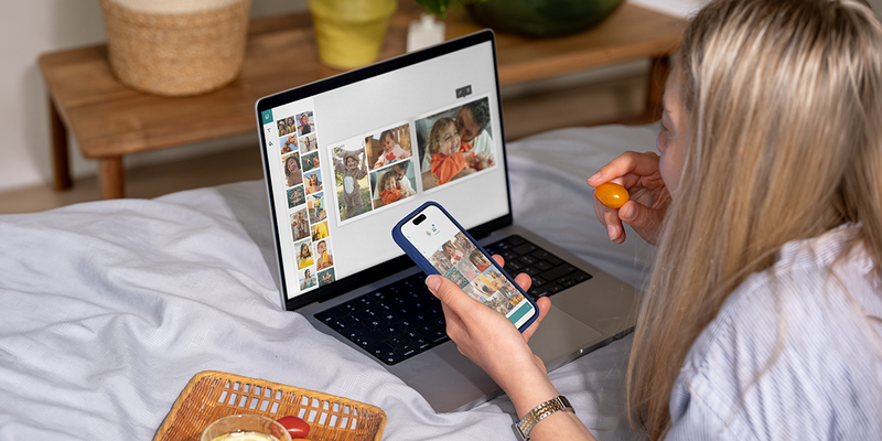 Una mujer usa el editor de escritorio de Hofmann en su portátil mientras come un tomate cherry para crear un fotolibro personalizado, como inspiración para un programa de fotolibros y un editor fácil de usar.