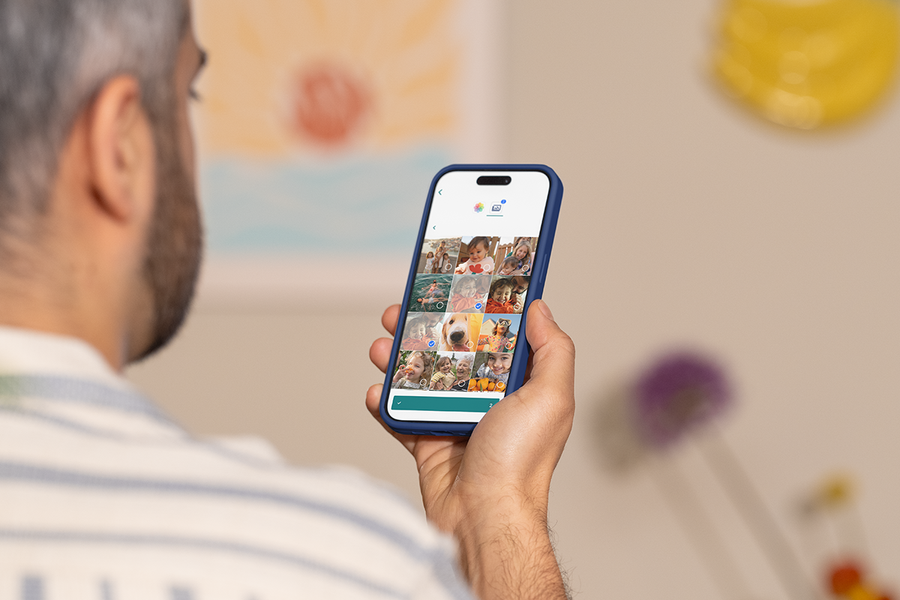 Una persona usa la app móvil de Hofmann en su teléfono para crear un producto fotográfico personalizado, como inspiración para un programa de fotolibros y un editor fácil de usar desde el móvil.