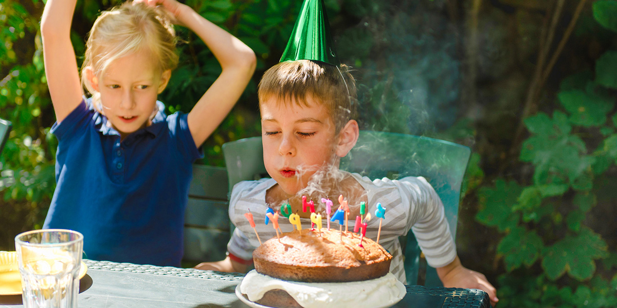 Un niño soplando las velas de su tarta de cumpleaños, como inspiración para Hofmann y para fiestas de cumpleaños para niños inolvidables.