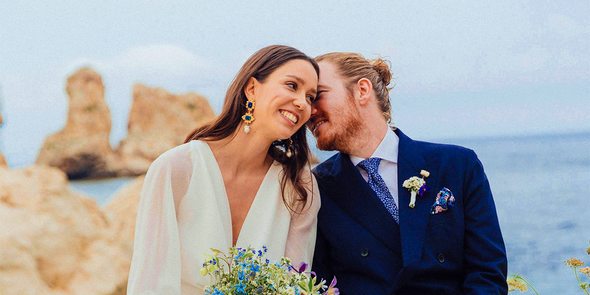 Una novia y un novio sonriendo en la playa el día de su boda, como inspiración para Hofmann y para juegos de boda y actividades para invitados.