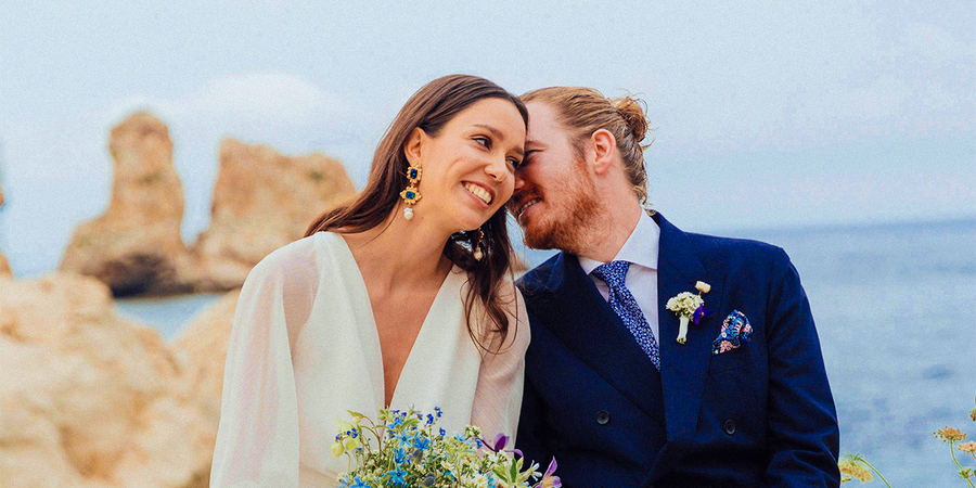 Una novia y un novio sonriendo en la playa el día de su boda, como inspiración para Hofmann y para juegos de boda y actividades para invitados.