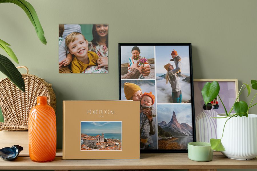Un fotolibro de viajes personalizado está junto a un collage de fotos enmarcado y una foto familiar en la pared, como inspiración para hacer que tu casa se sienta más acogedora con decoración fotográfica con significado.