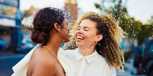 Una pareja sonriente el día de su boda, como inspiración para felicitaciones de boda y qué escribir en una tarjeta de boda.
