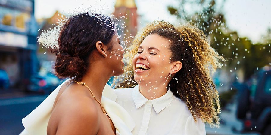 Una pareja sonriente el día de su boda, como inspiración para felicitaciones de boda y qué escribir en una tarjeta de boda.