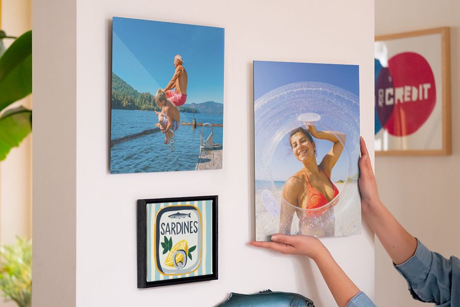 Una composición de cuadros personalizados de Hofmann muestra a una mujer sonriendo en la playa, a un hombre y un niño saltando al mar y una ilustración de una lata de sardinas, como inspiración para decoracion casa verano y decoraciones de verano para el hogar.