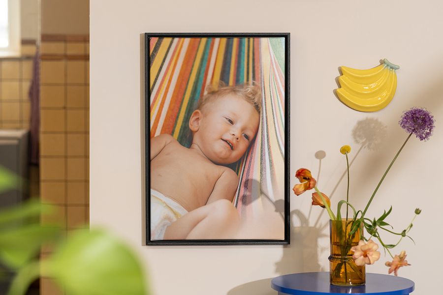 Un cuadro personalizado de Hofmann con la foto de un bebé junto a flores y decoración de frutas, como inspiración para la decoracion casa verano.