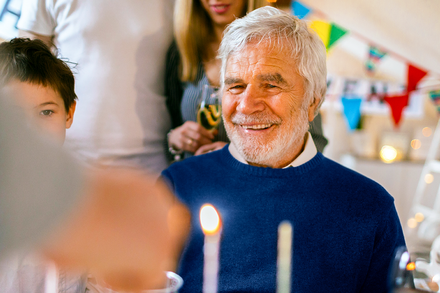 Un abuelo sonriendo en la celebración de su cumpleaños, una gran inspiración de regalos para padres cumpleaños o un regalo abuelo cumpleaños de Hofmann.