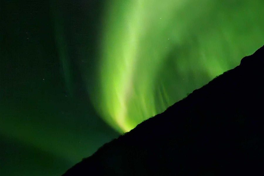Aurora boreal en el cielo de un verde muy intenso, que ilustra los consejos de composición de Hofmann para fotografiar auroras boreales.