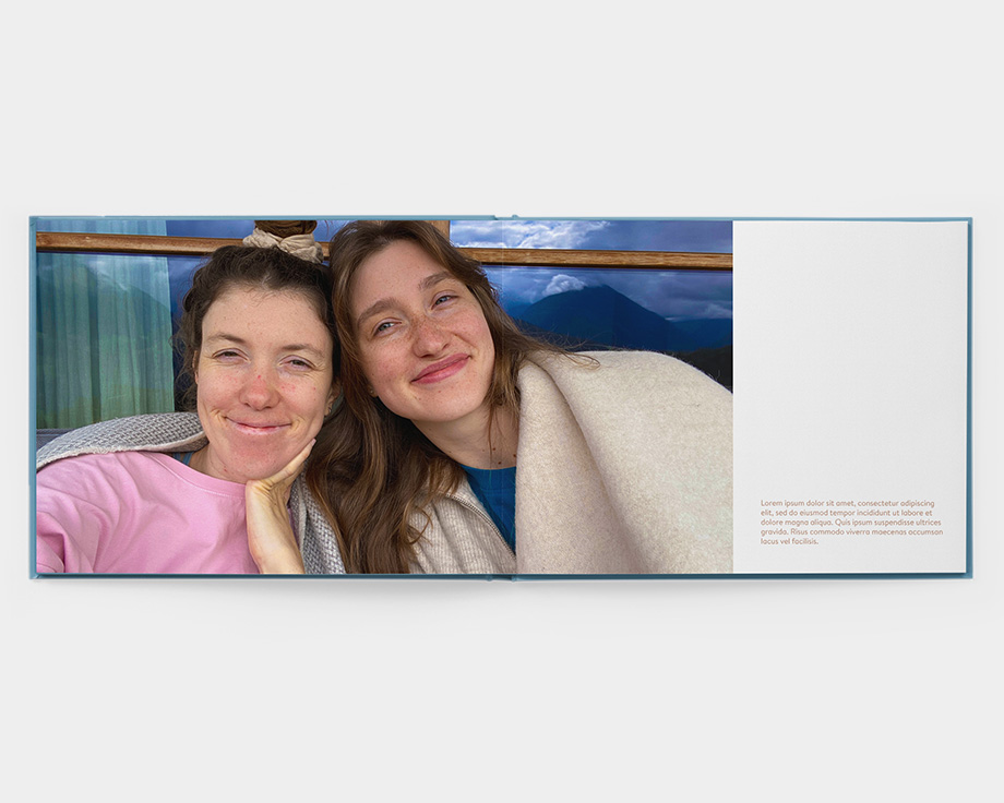 Un ábum apaisado de tapa acolchada abierto con una foto de dos mujeres sonriendo