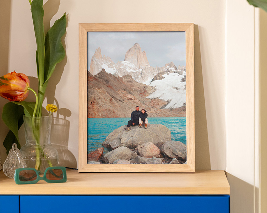 Foto de paisaje enmarcada apoyada en un estante de madera