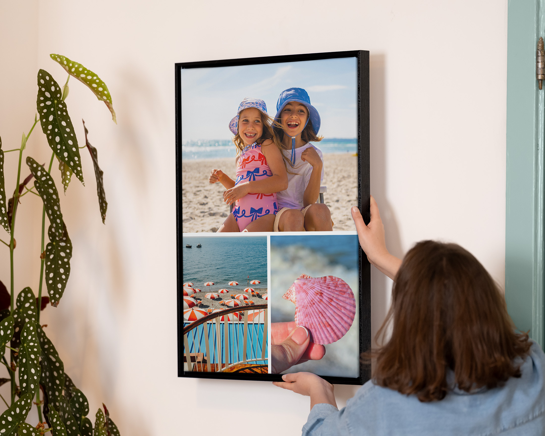 Una persona colgando un collage enmarcado