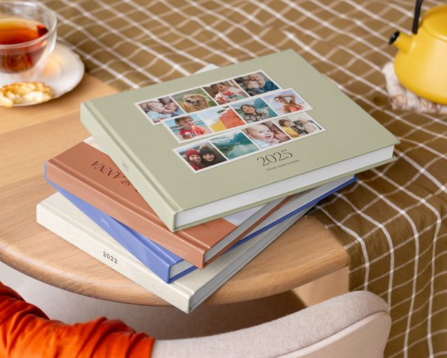 Pila de álbumes de fotos personalizados en una mesa