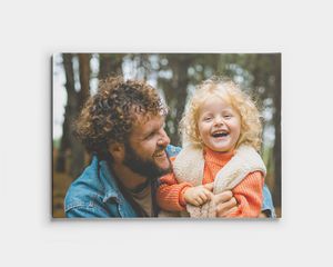 Lienzo de un padre y su hijo sonriendo en el bosque