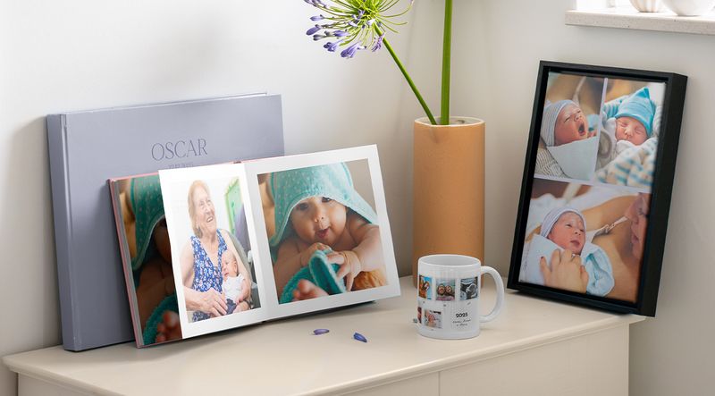 Regalos personalizados para bebé, como un álbum de fotos y cuadros enmarcados