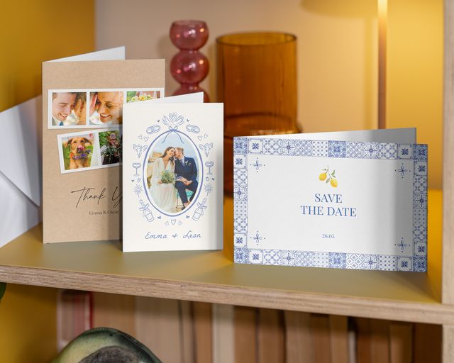 Tres tarjetas de boda con foto sobre una estantería: un recordatorio y dos tarjetas de agradecimiento.