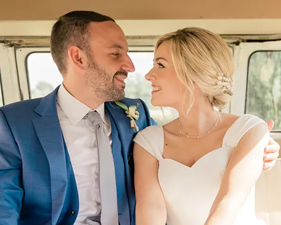 Fee, especialista en contenido editorial de Hofmann, y su esposo sonriendo en su coche de boda, ilustrando una historia personal sobre consejos para planificar una boda.